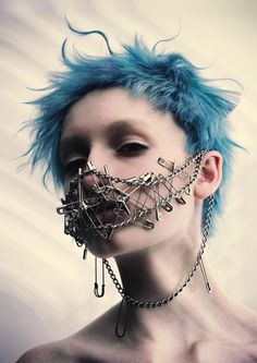 a woman with blue hair and chains on her face