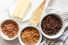 three bowls filled with different types of food on top of a white countertop next to cheese and crackers