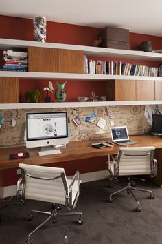 a desk with two chairs and a computer on it in front of bookshelves