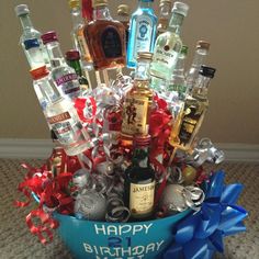 a blue bowl filled with liquor bottles and confetti on top of a carpeted floor