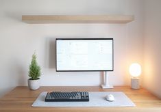 a computer monitor sitting on top of a wooden desk next to a keyboard and mouse