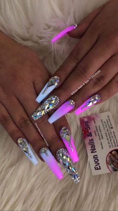 a woman's hand with pink and white nail polishes on her nails, while holding