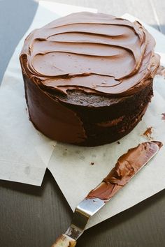 a chocolate cake sitting on top of a table next to a knife