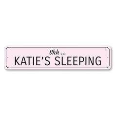 a pink street sign with the words kate's sleeping on it