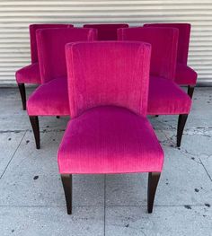 four pink chairs sitting next to each other