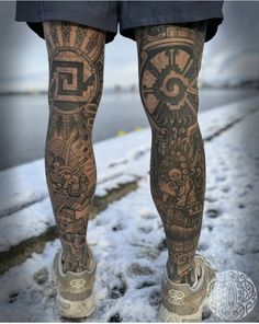 a man's legs with tattoos on them in the snow