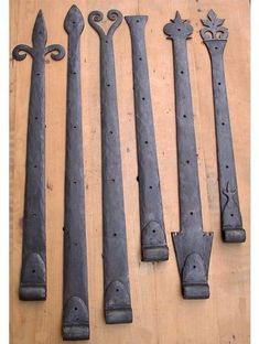 five old iron door handles on top of a wooden table