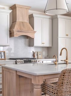 a kitchen with white cabinets and an island in the middle is decorated with wicker chairs