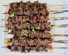 skewered meat with sesame seeds and garnishes