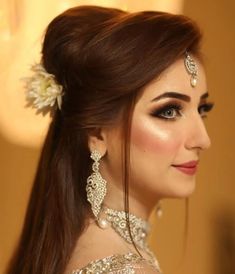 a woman with long brown hair wearing jewelry