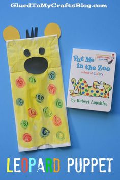 a paper bag with a bear face on it and a book next to it that says, put me in the zoo