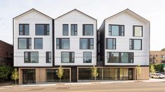 the three story building has many windows on each floor and is white with black trim