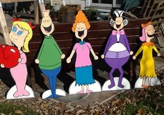 some cut outs of cartoon characters are standing in front of a park bench with leaves on the ground