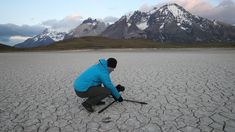 a man kneeling down in the middle of a desert