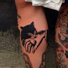 two people with tattoos on their legs, one has a cat and the other has a dog