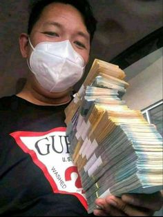 a man wearing a face mask and holding stacks of money