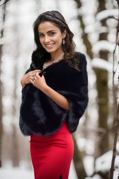 a woman in a red dress and black fur stoler posing for the camera with her hands on her hips