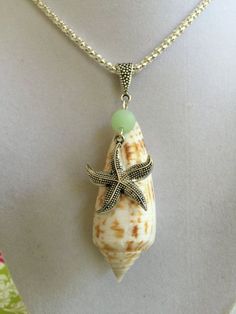 a necklace with a starfish on it and a green bead hanging from the back