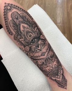 a black and white tattoo on the arm of a woman with an ornate design in it