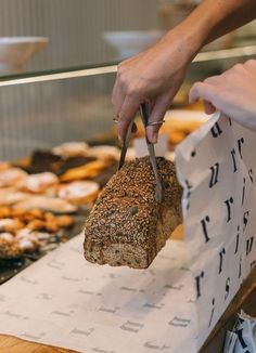 a person cutting up a loaf of bread