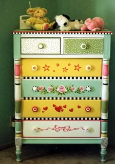 a colorful dresser with teddy bears and stuffed animals on it's top tiers