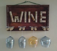 wine corks are hanging on the wall next to three glass vases and a sign that says wine