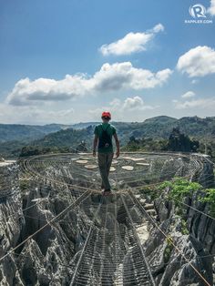 a man standing on top of a rope bridge