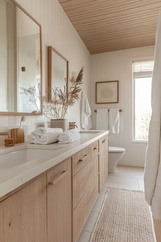 a bathroom with wooden cabinets and white walls