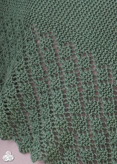 there is a green crocheted blanket on the bed