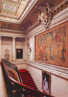 an ornate staircase with paintings on the wall