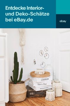 a stack of books sitting on top of a wooden floor next to a potted plant