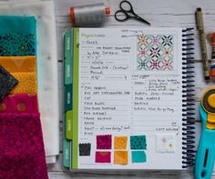 an open notebook sitting on top of a table next to scissors and other crafting supplies