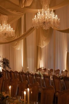 an elegant banquet hall with chandeliers and tables