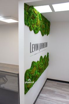 an office wall with moss growing on it and the words levin johnson written in black