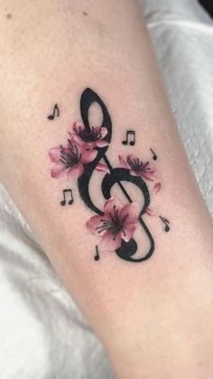 a tattoo with music notes and flowers on it