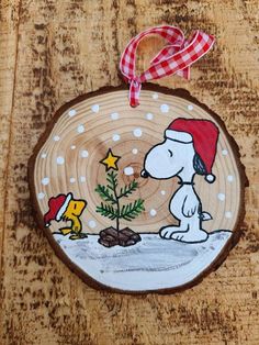 a wooden ornament with a snoopy christmas tree and charlie brown on it