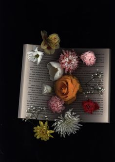 an open book with flowers on it