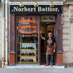 a man standing in front of a shoe store with his hand up to the door