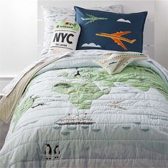 a bed with a map and airplane pillows on it