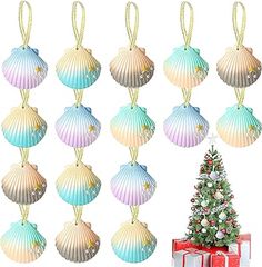 a christmas tree and twelve seashells hanging from strings in front of a white background