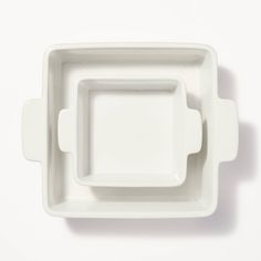 an empty white square dish on a white surface