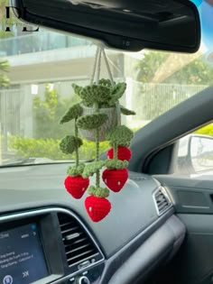 crocheted strawberries hanging from the dashboard of a car