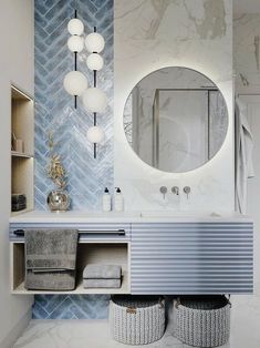 a bathroom with blue and white tiles on the wall, two round lights above the sink