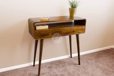 a small wooden desk with a plant on top