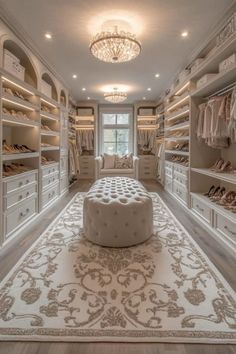 a large walk in closet with lots of white furniture