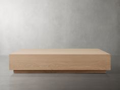 a wooden box sitting on top of a cement floor in front of a gray wall