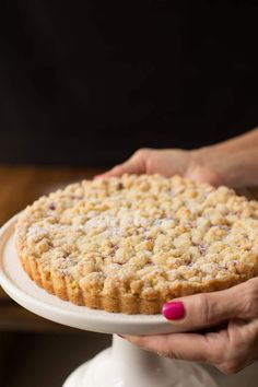 a person holding a cake on a white plate