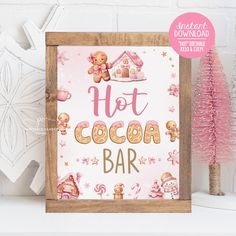 a wooden sign that says hot cocoa bar next to a pink christmas tree and snowflakes