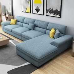 a large blue couch sitting on top of a hard wood floor next to a wooden table