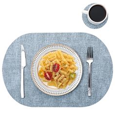 a white plate topped with pasta and fruit next to a cup of coffee on top of a blue place mat